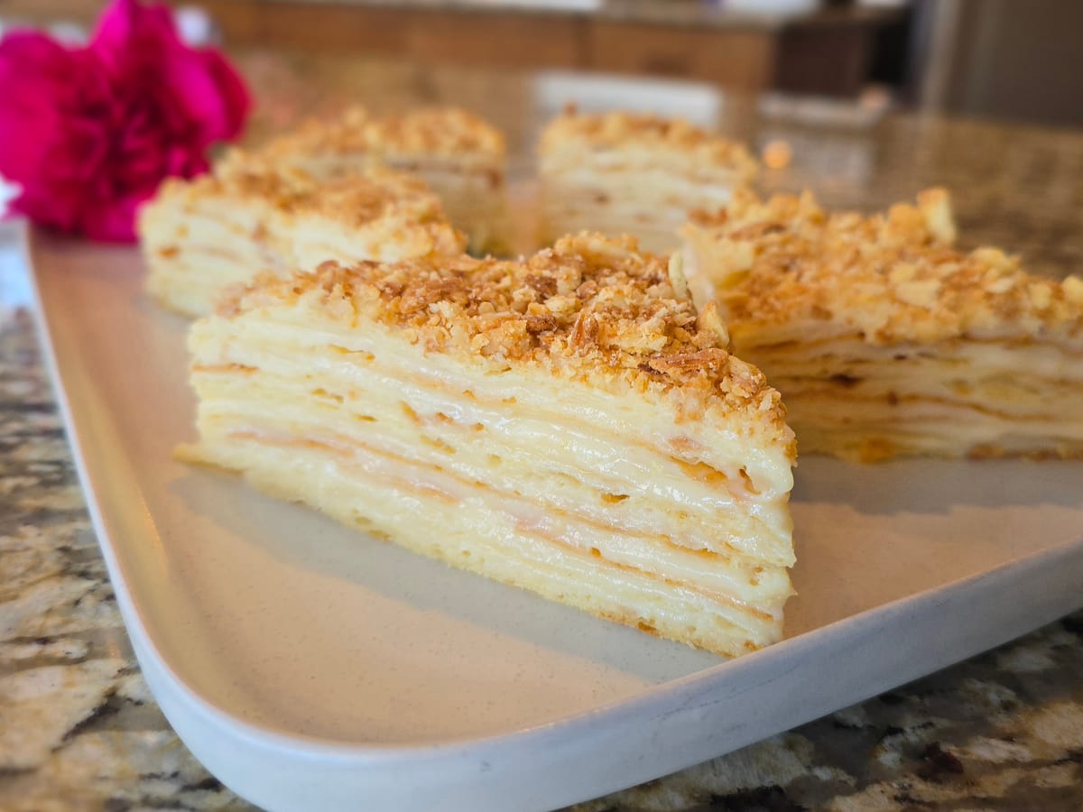 Elegant Napoleon Torte with golden crispy puff pastry layers and creamy pastry filling, topped with powdered sugar