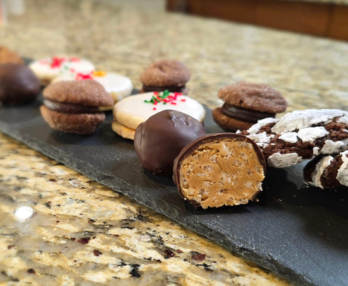 Golden peanut butter rice crispy chocolate balls stacked on a white plate, coated in rich dark chocolate with a glimpse of the crunchy peanut butter center