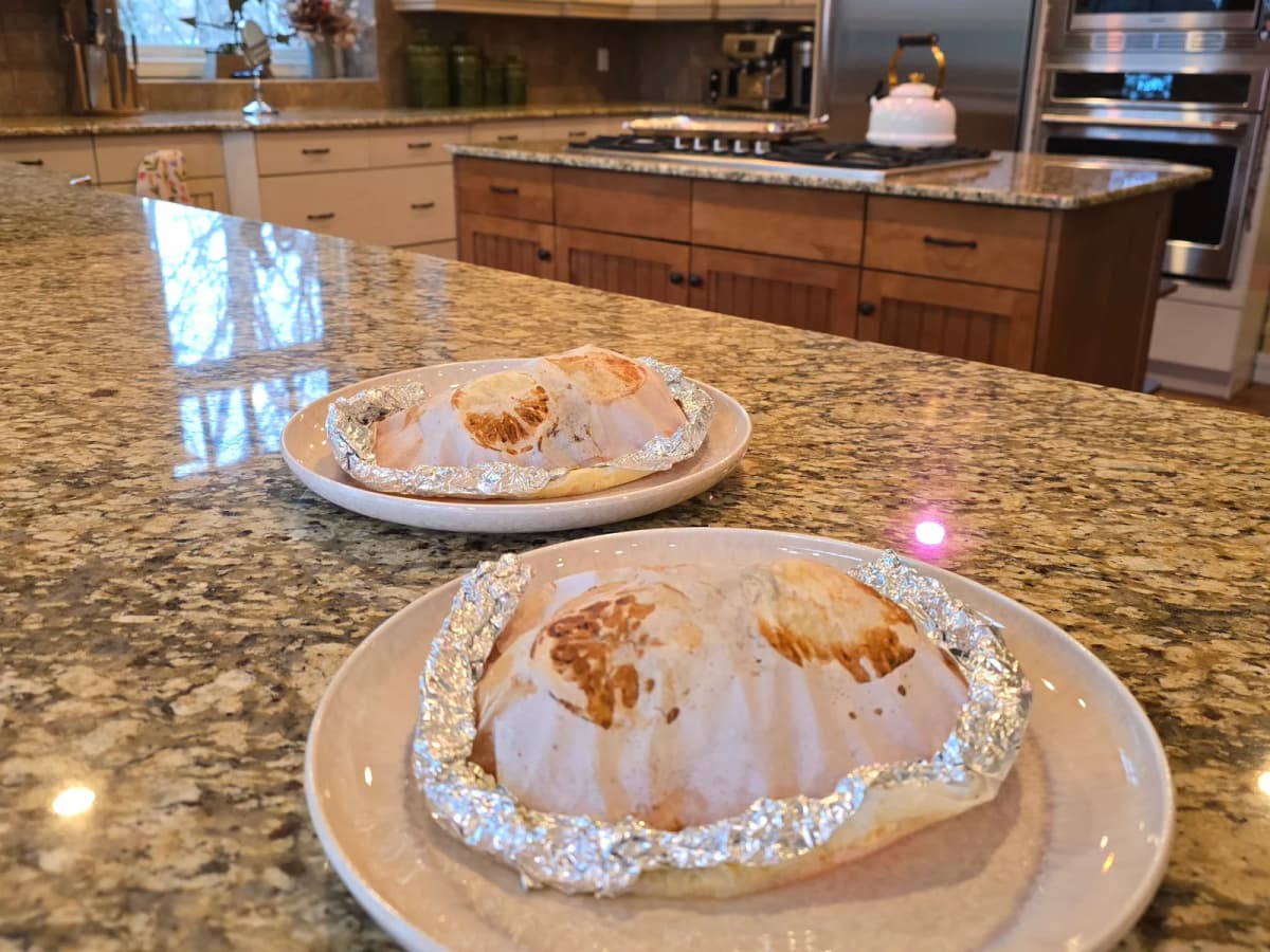 Steamed chicken breast and sweet potato in opened parchment paper with fresh herbs