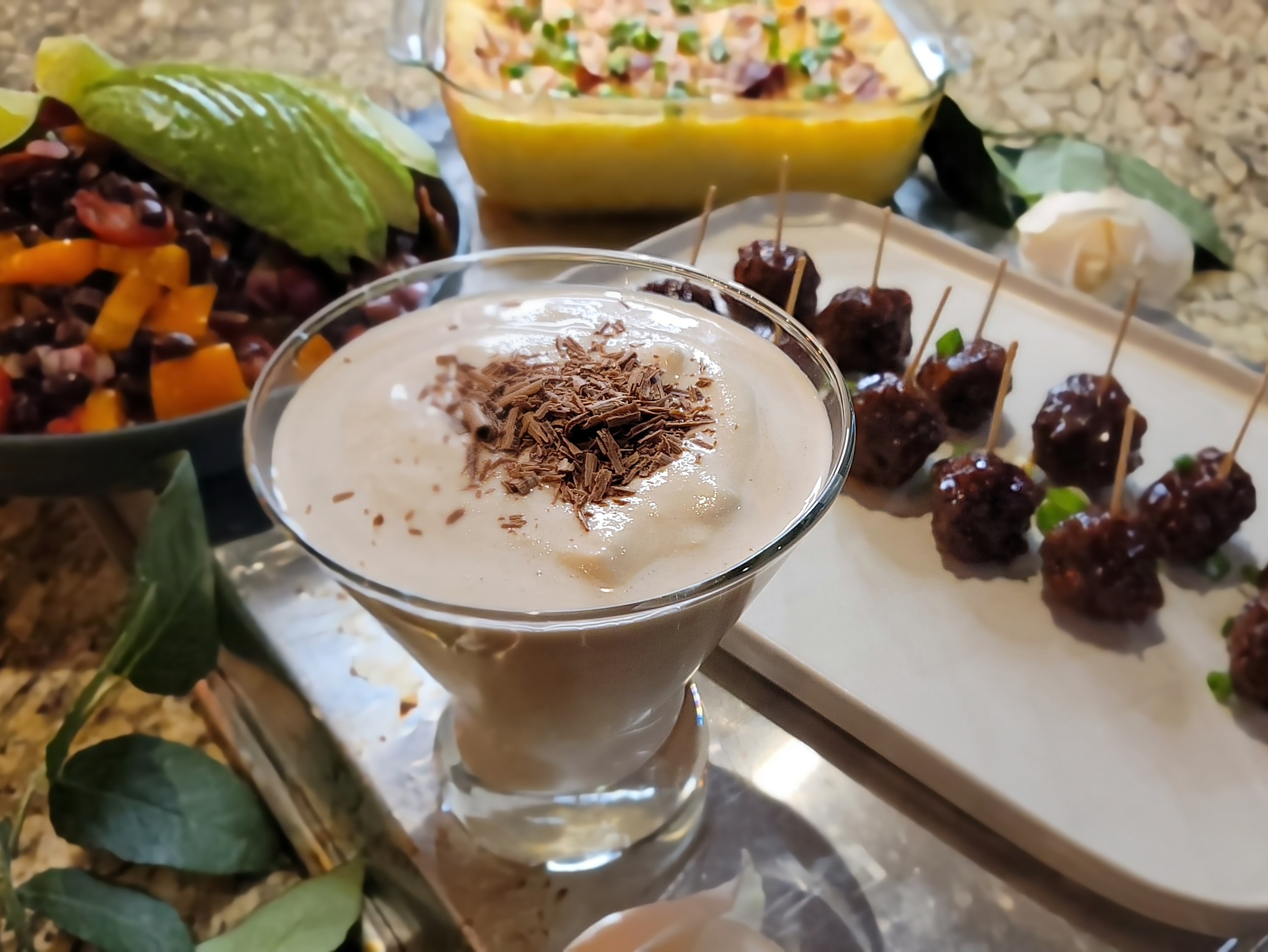 Frozen mudslide cocktail in a glass with chocolate shavings, vanilla ice cream foam, and crushed ice
