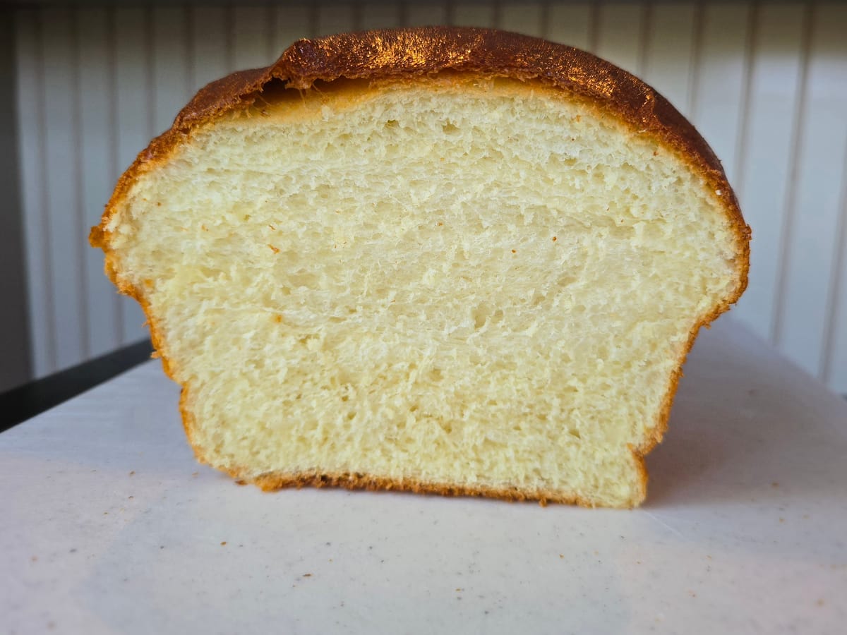 Soft, fluffy Hokkaido milk bread loaf with golden-brown crust, sliced to show pillowy white crumb structure