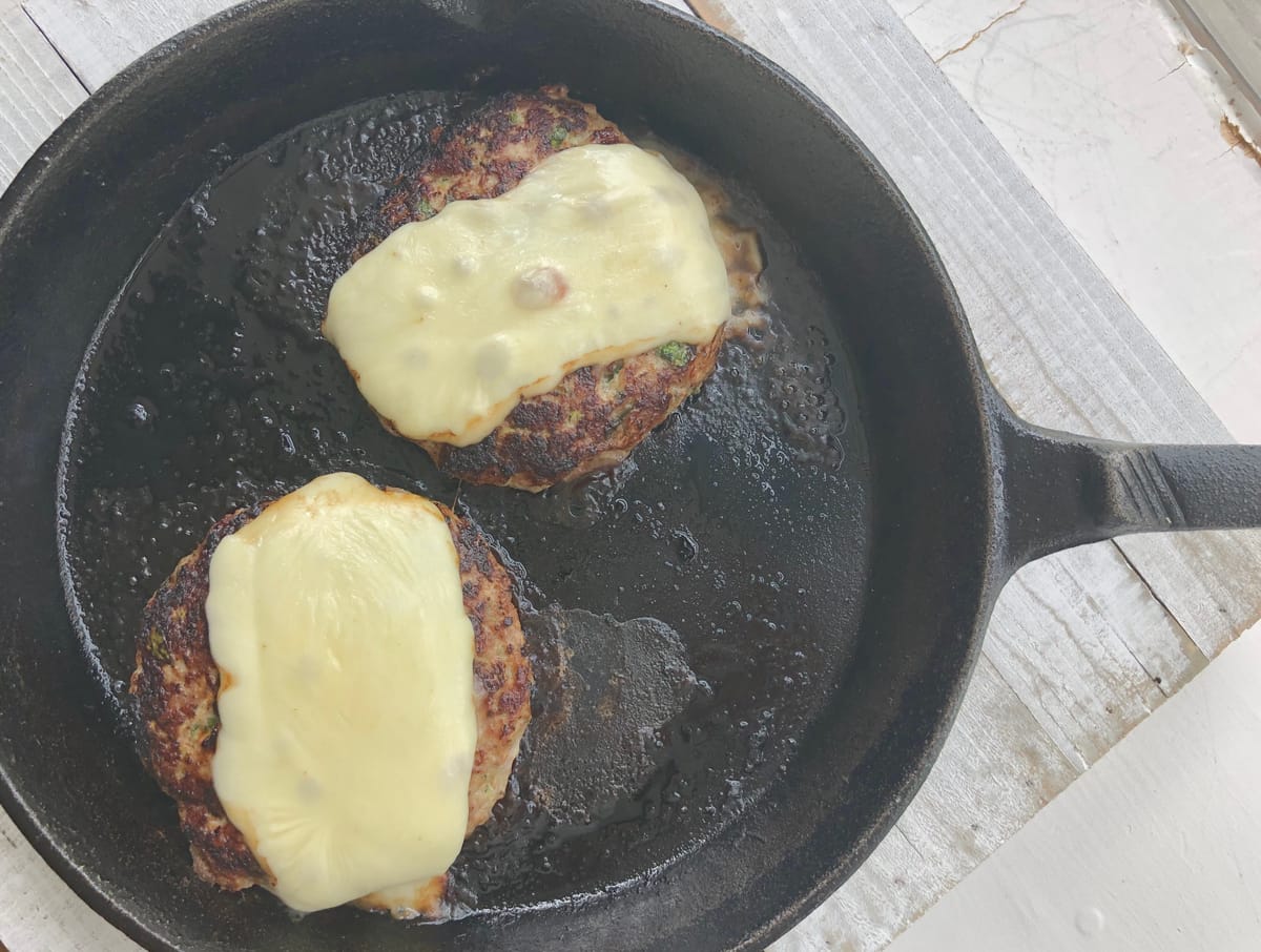 Golden roasted turkey on a white platter with fresh herbs and roasted vegetables, ready to serve