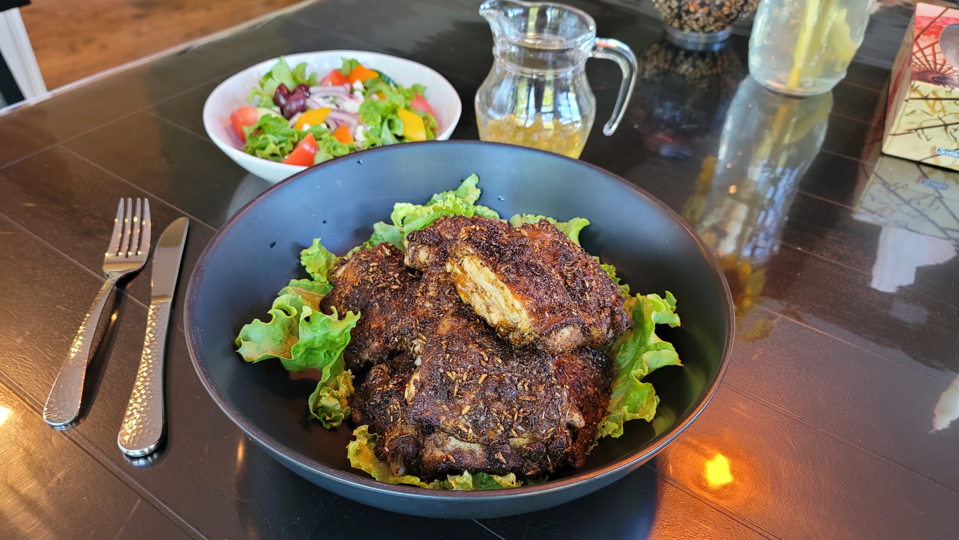 Golden-seared blackened chicken thighs with smoky spice crust on a white plate, garnished with fresh parsley