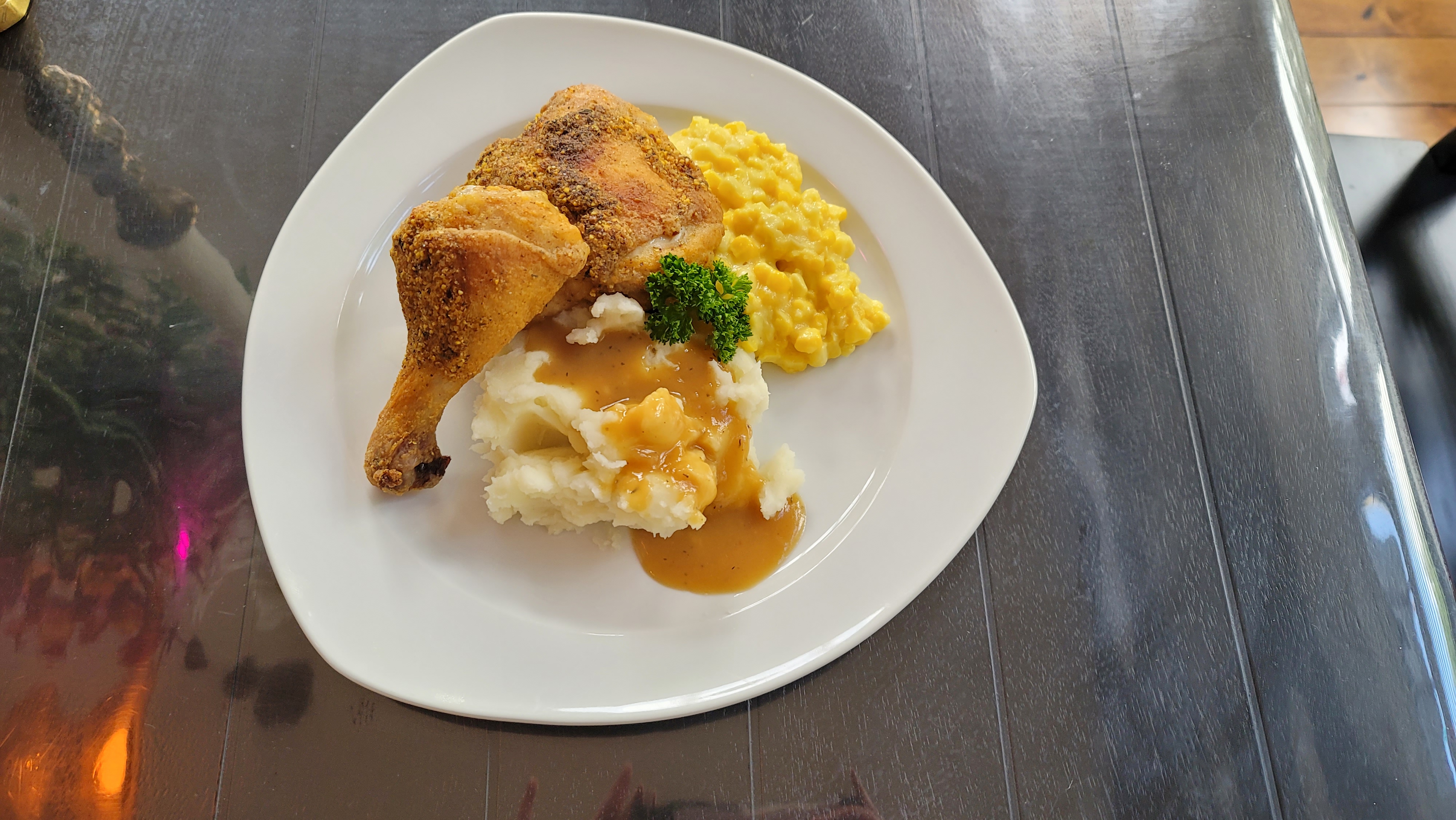 Golden crispy oven-fried chicken legs on a white plate with a cornmeal and flour coating, juicy and perfectly seasoned