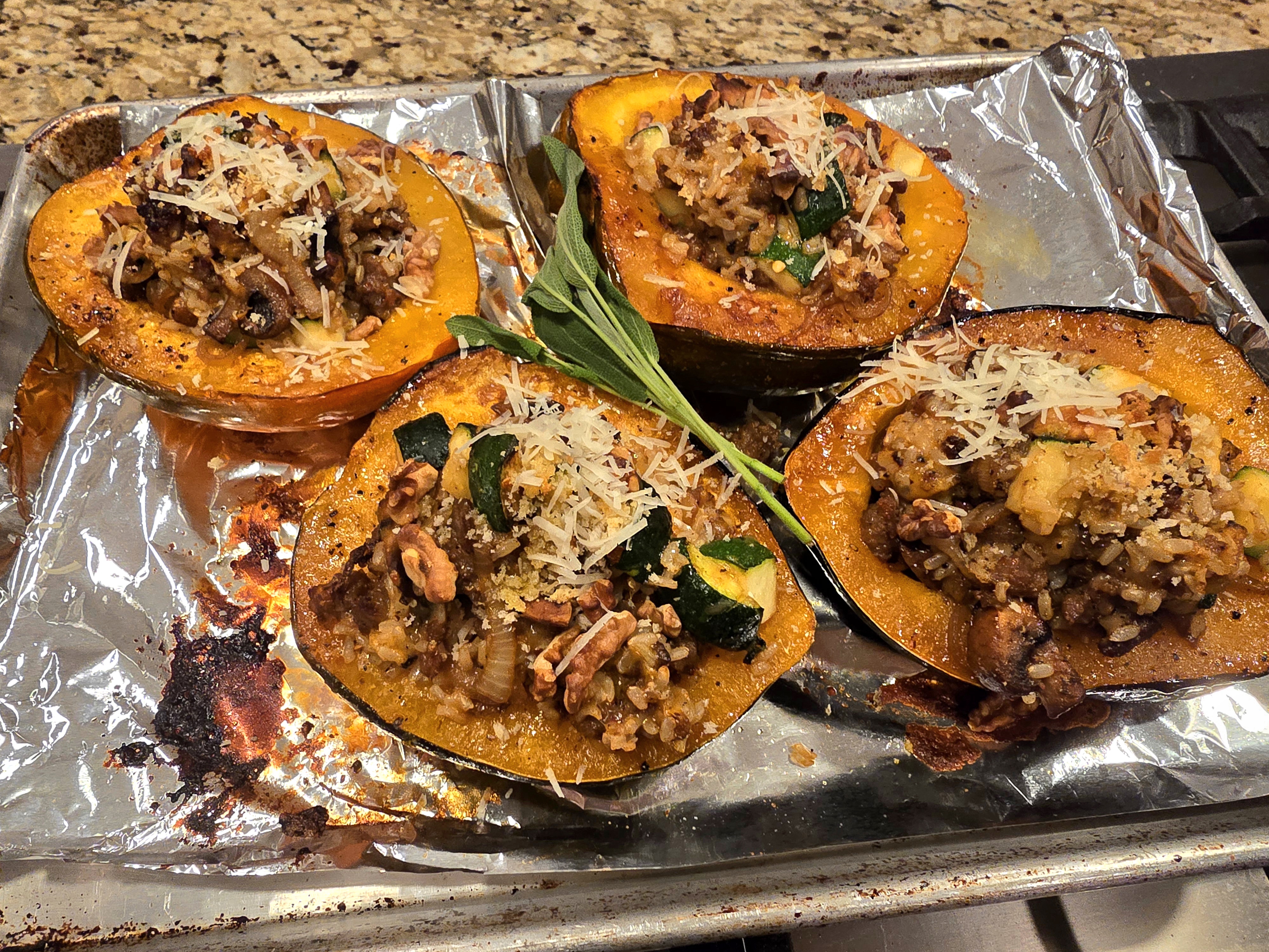 Halved acorn squash stuffed with Italian sausage, brown rice, mushrooms, and topped with toasted walnuts and maple glaze on a dark plate