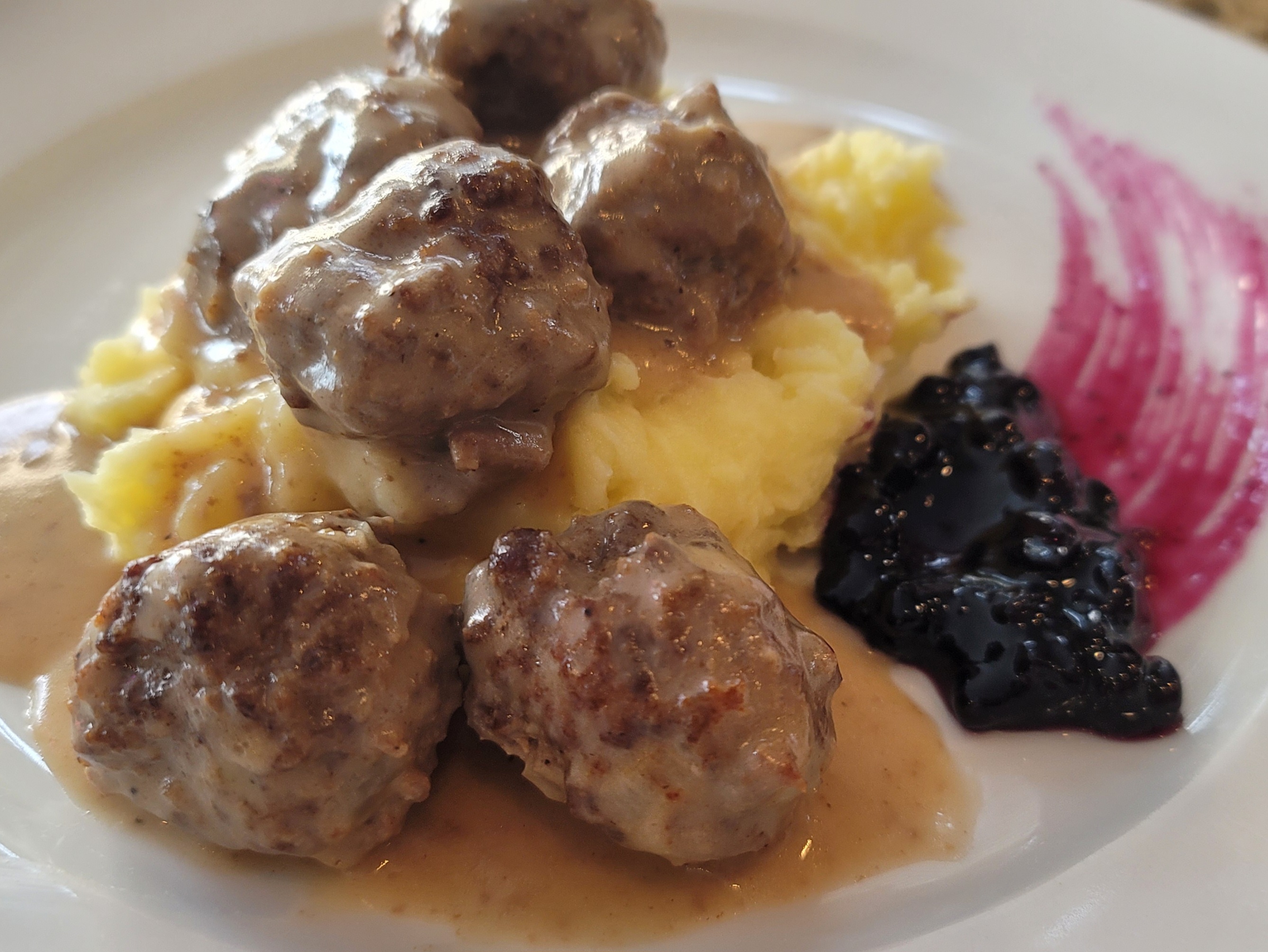 Swedish meatballs in creamy sauce served on a white plate with fresh parsley garnish